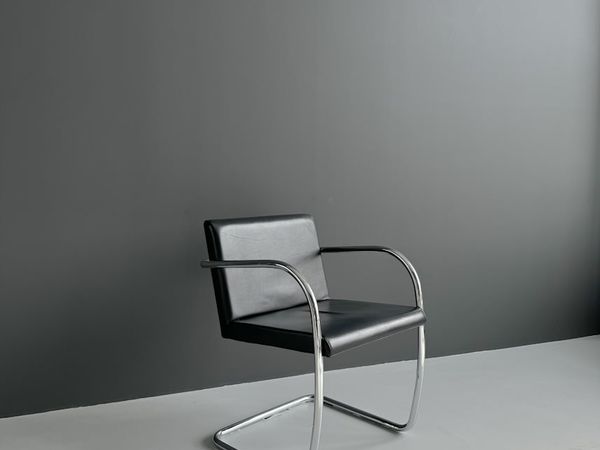 Juoda kėdė su porankiais